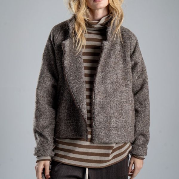 Kurtka Mino Wool delCane w brązowym melanżu. Mocne zbliżenie od przodu, modelka widoczna od ud w górę, prezentuje rozpiętą kurtkę z włoskiej wełny.