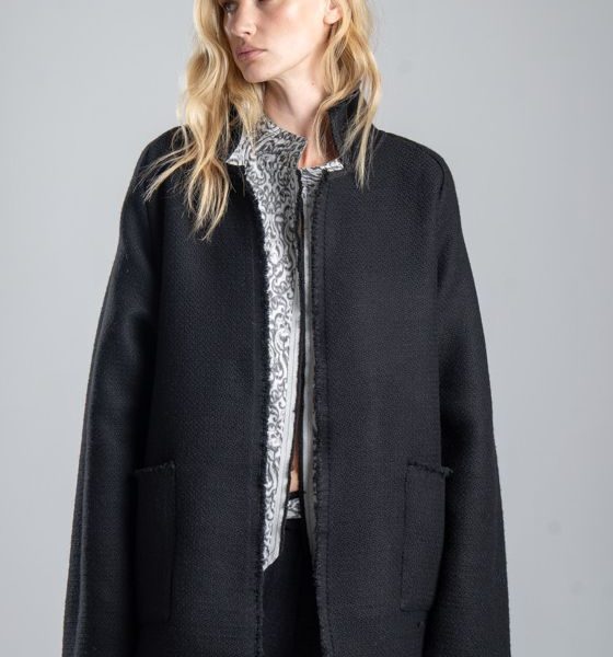 Marynarka Mino Noir delCane w głębokim odcieniu czerni. Modelka przodem, w ujęciu od uda w górę. Wyraźnie widoczny przód marynarki i jej luźny fason oversize.