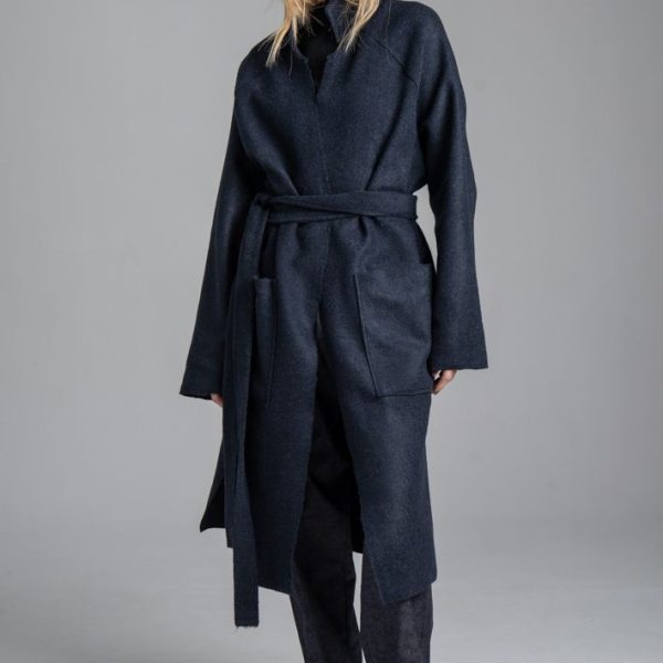 Granatowy płaszcz Mino Wool delCane, zdjęcie główne. Modelka przodem, w pełnej sylwetce, z rękami opuszczonymi wzdłuż ciała. Płaszcz zawiązany paskiem w talii.